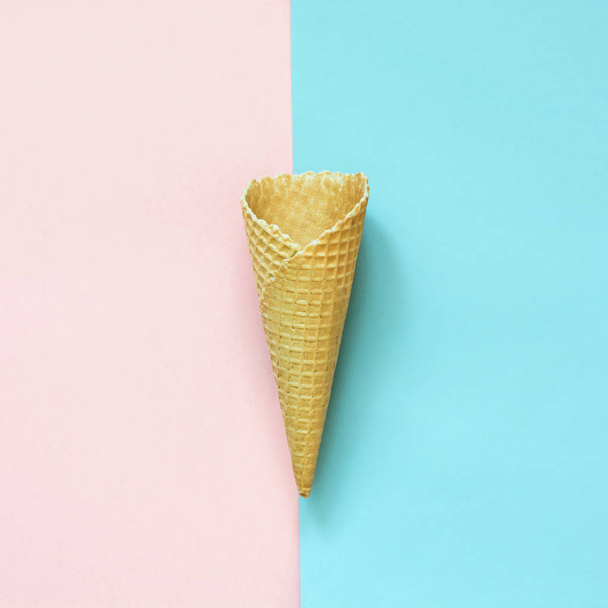 Creative still life of empty waffle cone on pink and blue background. Top view. - Fotó, kép