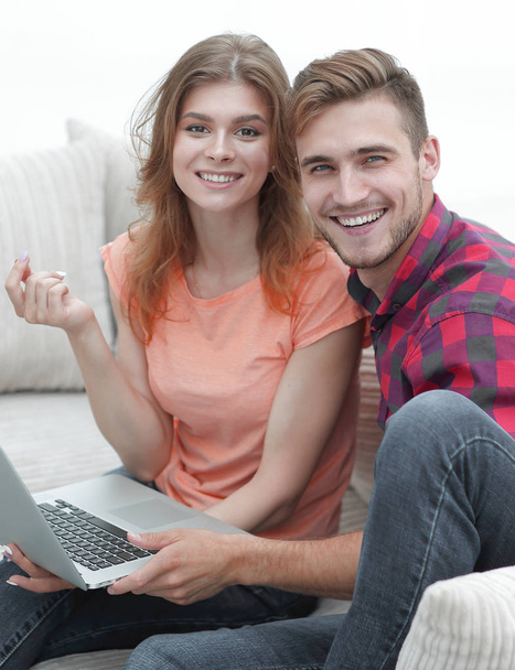 pair students with a laptop sitting on sofa - Foto, immagini