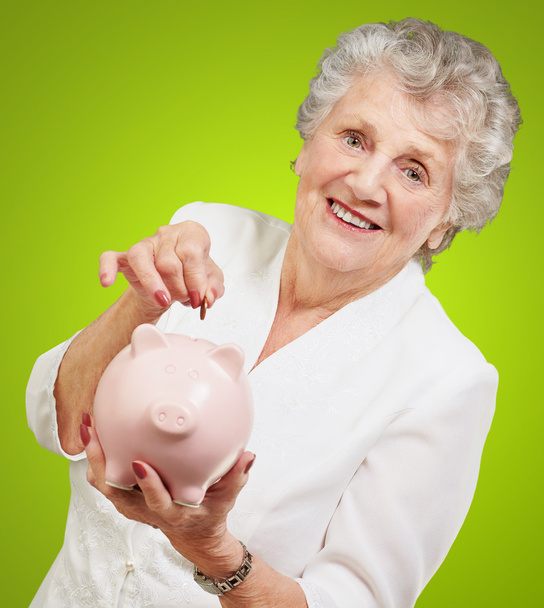 Portret van een volwassen vrouw met een piggy bank - Foto, afbeelding
