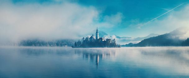 Amazing view on a misty morning of lake Bled with St. Marys Church of the Assumption on the small island; Bled, Slovenia, Europe. - Фото, изображение