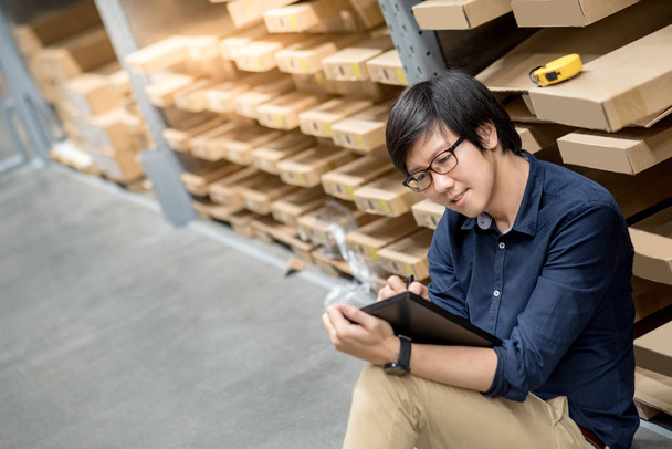 Молодой азиат делает инвентаризацию с помощью планшета на складе
 - Фото, изображение