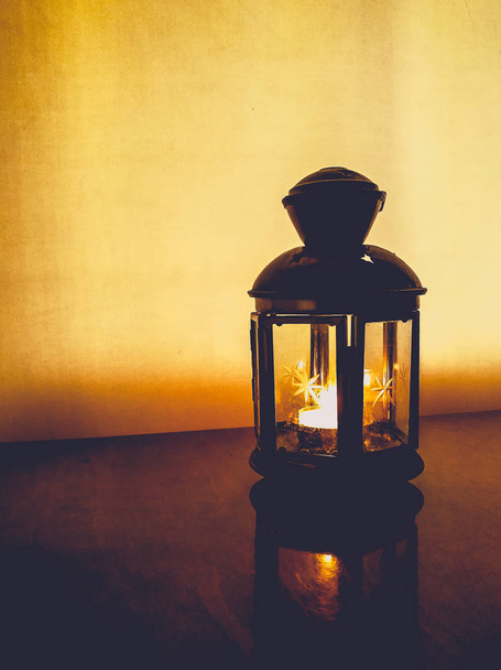 Burning candle in a metal lantern  - 写真・画像