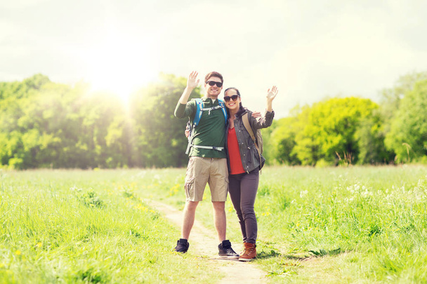 happy couple with backpacks hiking outdoors - Valokuva, kuva
