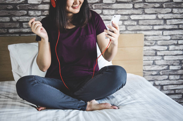 Young woman have fun on bedroom in enjoying listen the music wit - 写真・画像
