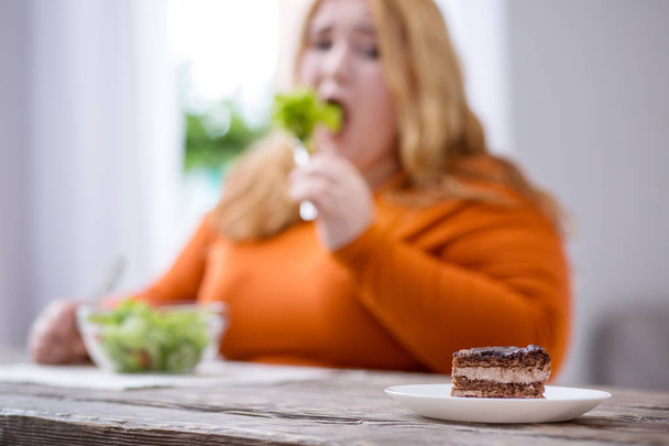 Desolate plump woman looking at cookies - Photo, Image