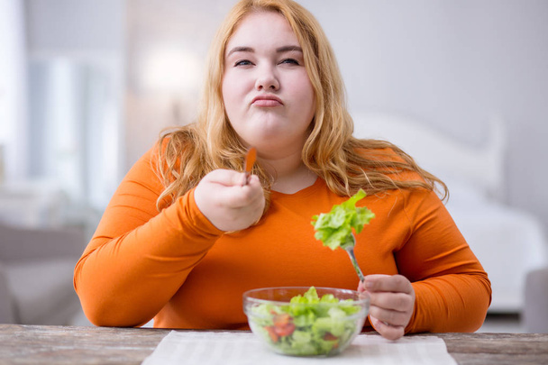 Determined fat woman eating healthy breakfast - Zdjęcie, obraz