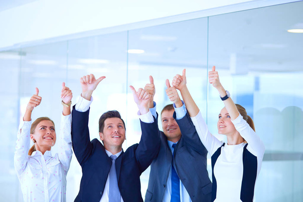 Ευτυχισμένος επιχειρηματική ομάδα δείχνει τους αντίχειρες επάνω στο γραφείο. Ευτυχισμένος επιχειρηματική ομάδα - Φωτογραφία, εικόνα