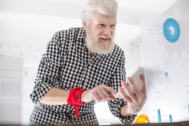 Homme âgé aux cheveux blancs vérifiant les données de l'écran
 - Photo, image