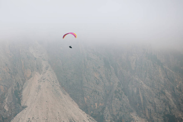 Paraglider sorvolando montagne nelle dolomiti, Italia. Soleggiato giorno d'autunno. - Foto, immagini