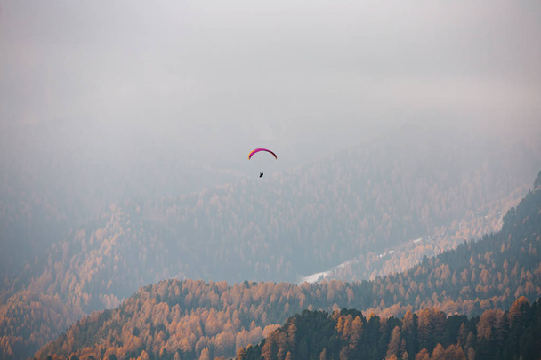 Paraglider flying over mountains in the dolomites, Italy. Sunny autumn day. - Valokuva, kuva
