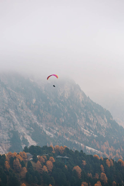 Siklóernyő repül át hegyek a dolomitok, Olaszország. Napos őszi nap. - Fotó, kép