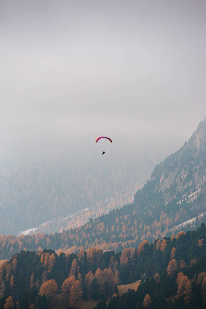 Parapente volando sobre las montañas en la dolomita, Italia. Día soleado del otoño. - Foto, Imagen