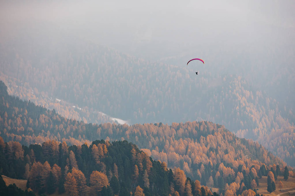 Parapente volando sobre las montañas en la dolomita, Italia. Día soleado del otoño. - Foto, Imagen