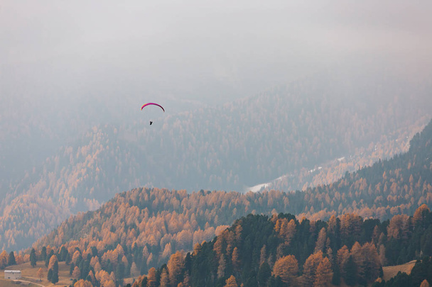 Лидер пролетает над горами в дождевых клещах, Италия. Солнечный осенний день. - Фото, изображение