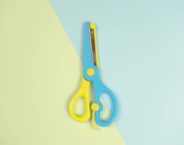blue and yellow colourful scissors on on blue and green background. beautiful colourful picture copcept The same as the difference, minimal style - Photo, Image