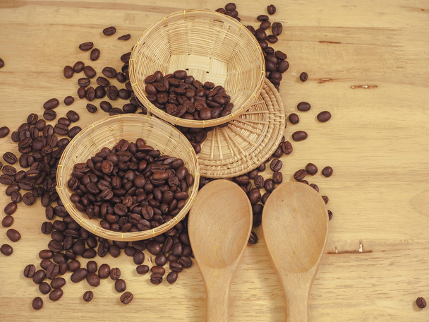 grains de café dans un petit panier et cuillère en bois sur lattes en bois
 - Photo, image
