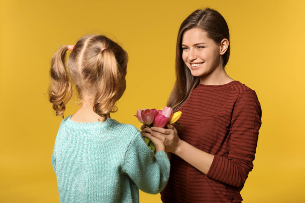 little girl giving mother bouquet of flowers - Foto, imagen