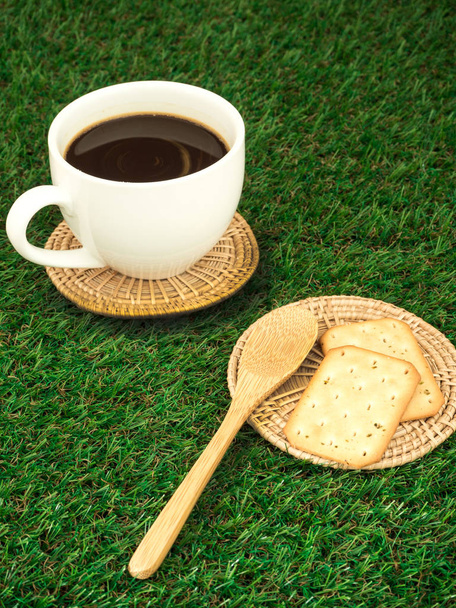 Filiżanka kawy i ziaren kawy na zielonym tle trawy - Zdjęcie, obraz
