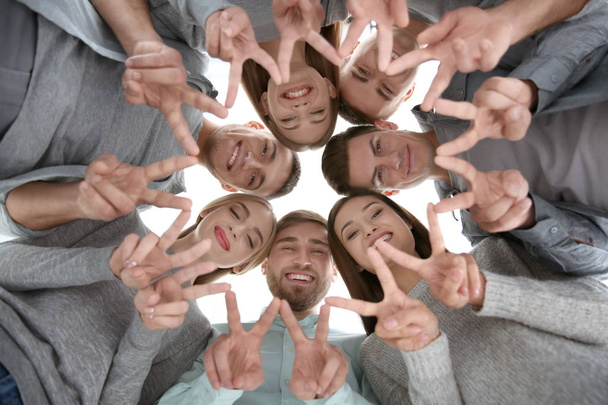 Молодые люди показывают победный жест
  - Фото, изображение