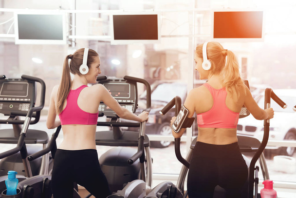Women in sportswear running on treadmill at gym - Фото, изображение