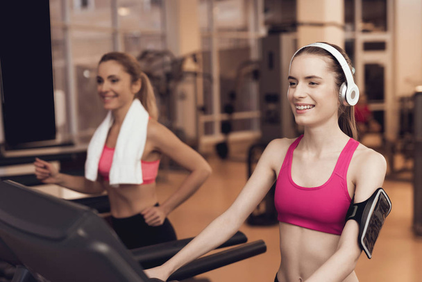 Women in sportswear running on treadmill at gym - Foto, afbeelding