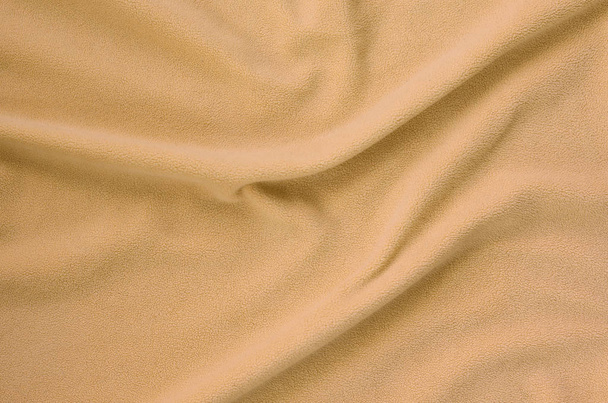 Koc furry pomarańczowy Polar tkanina. Tło światło pomarańczowe polarem pluszowe materiału z dużą ulgą fałdy - Zdjęcie, obraz
