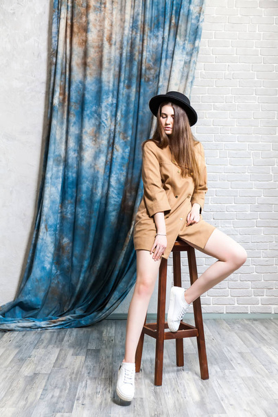 Studio shot van een jonge vrouw in elegante jas en klassieke hoed. Schoonheid, mode concept. - Foto, afbeelding
