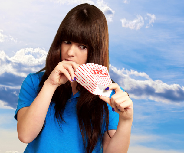 girl looking through empty popcorn packet - Photo, Image