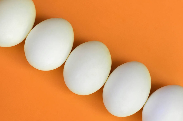 A few white easter eggs on a bright orange background - Fotoğraf, Görsel