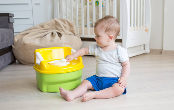 Roztomilé batole chlapec při pohledu na WC baby pot - Fotografie, Obrázek
