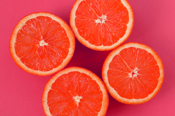 Top view of a several grapefruit slices on bright background in pink color. A saturated citrus texture image - Photo, Image