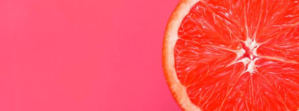 Pohled shora z jednoho grapefruitu řezu na světlé pozadí ve světle růžové barvě. Nasycený citrusových textury obrazu - Fotografie, Obrázek