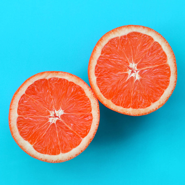 Top view of a several grapefruit slices on bright background in blue color. A saturated citrus texture image - Photo, image