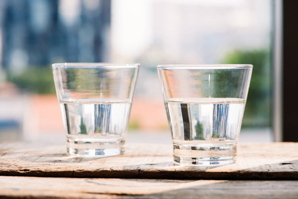 Dwie szklanki wody na stole na drewniane tła - Zdjęcie, obraz