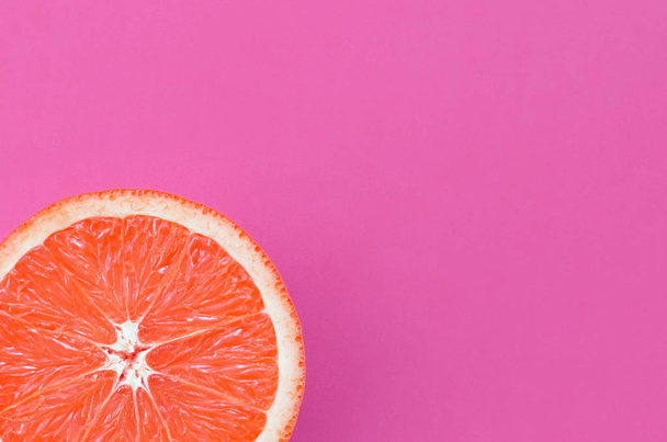 Pohled shora z jednoho grapefruitu řezu na světlé pozadí ve fialové barvě. Nasycený citrusových textury obrazu - Fotografie, Obrázek