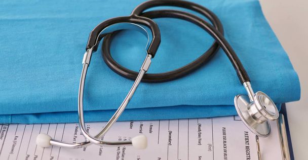ein Stethoskop, das ein Herz auf medizinischer Uniform formt, Nahaufnahme, selektiver Fokus - Foto, Bild