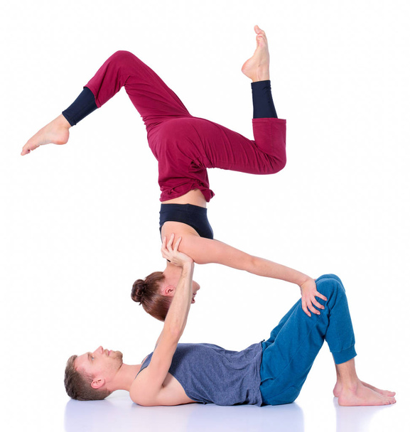 Young athletic couple practicing acroyoga. Balancing in pair - Foto, Imagem