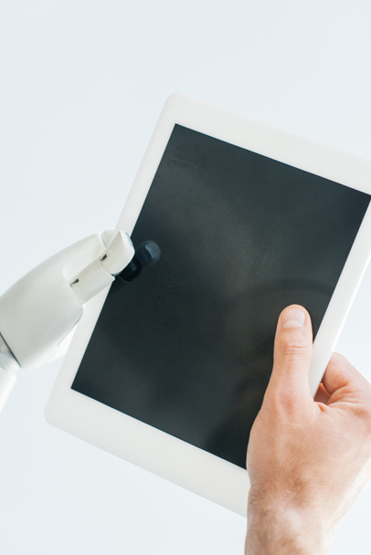 close-up view of human hand and robotic arm holding digital tablet with blank screen isolated on white - Valokuva, kuva