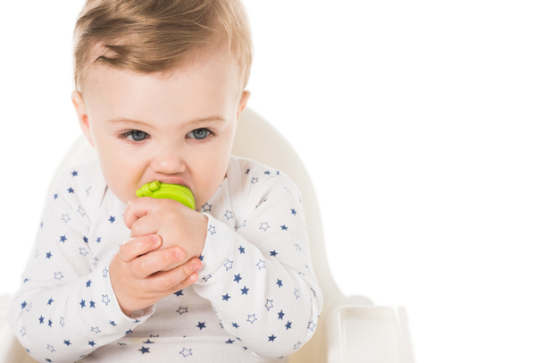 little boy with baby pacifier sitting in highchair isolated on white background  - Foto, imagen