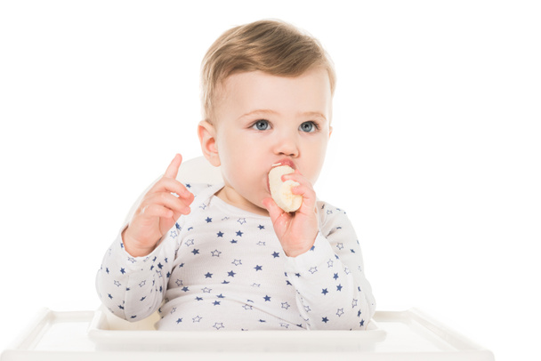 Junge mit erhobenem Finger isst Banane isoliert auf weißem Hintergrund  - Foto, Bild