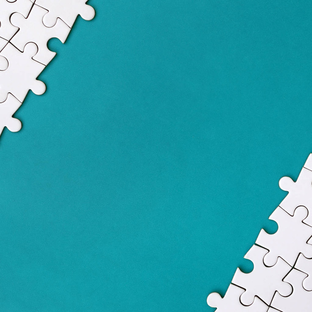 Fragment d'un puzzle blanc plié sur le fond d'une surface en plastique bleu. Texture photo avec espace de copie pour le texte
 - Photo, image