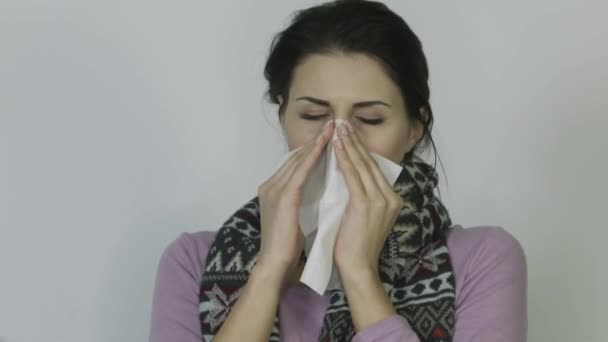 Άρρωστο κορίτσι σε ένα μαντίλι με θερμοκρασία φυσώντας τη μύτη της σε λευκό φόντο - Πλάνα, βίντεο