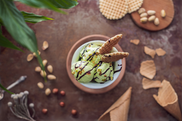 top view of pistachio ice cream with waffles in glass on tabletop - Zdjęcie, obraz