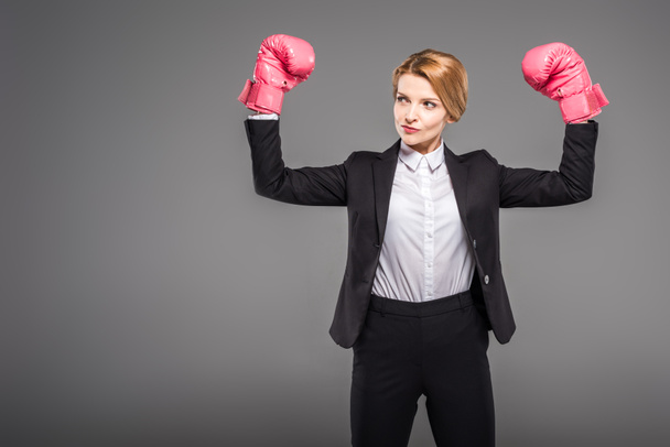fuerte mujer de negocios posando en guantes de boxeo, aislado en gris
 - Foto, Imagen