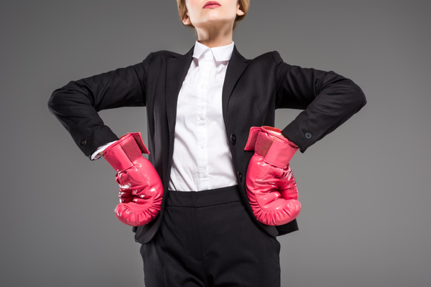 cropped view of strong businesswoman posing in suit and pink boxing gloves, isolated on grey - Φωτογραφία, εικόνα