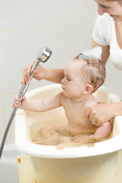 Retrato de jovem mãe lavando seu menino em ath
 - Foto, Imagem