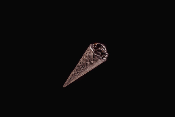 top view of one black ice cream isolated on black - Foto, Imagem