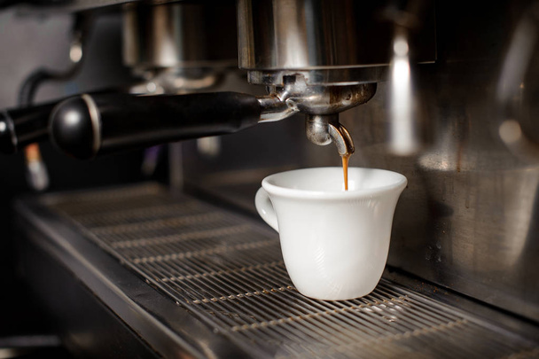 Witte keramische kop koffie in de koffie-mahine - Foto, afbeelding