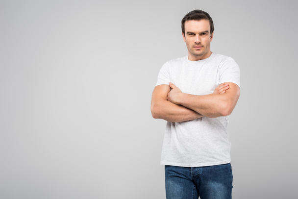 handsome man with crossed arms looking at camera, isolated on grey  - Foto, imagen