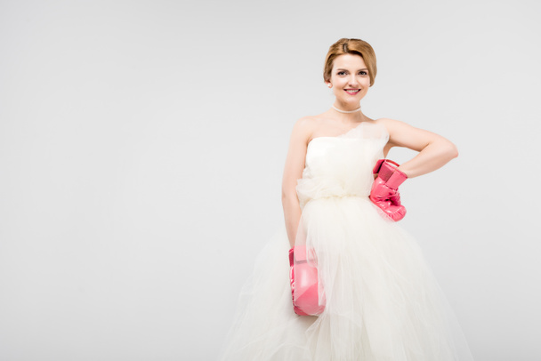 beautiful bride posing in wedding dress and boxing gloves, isolated on grey, feminism concept - Foto, Bild
